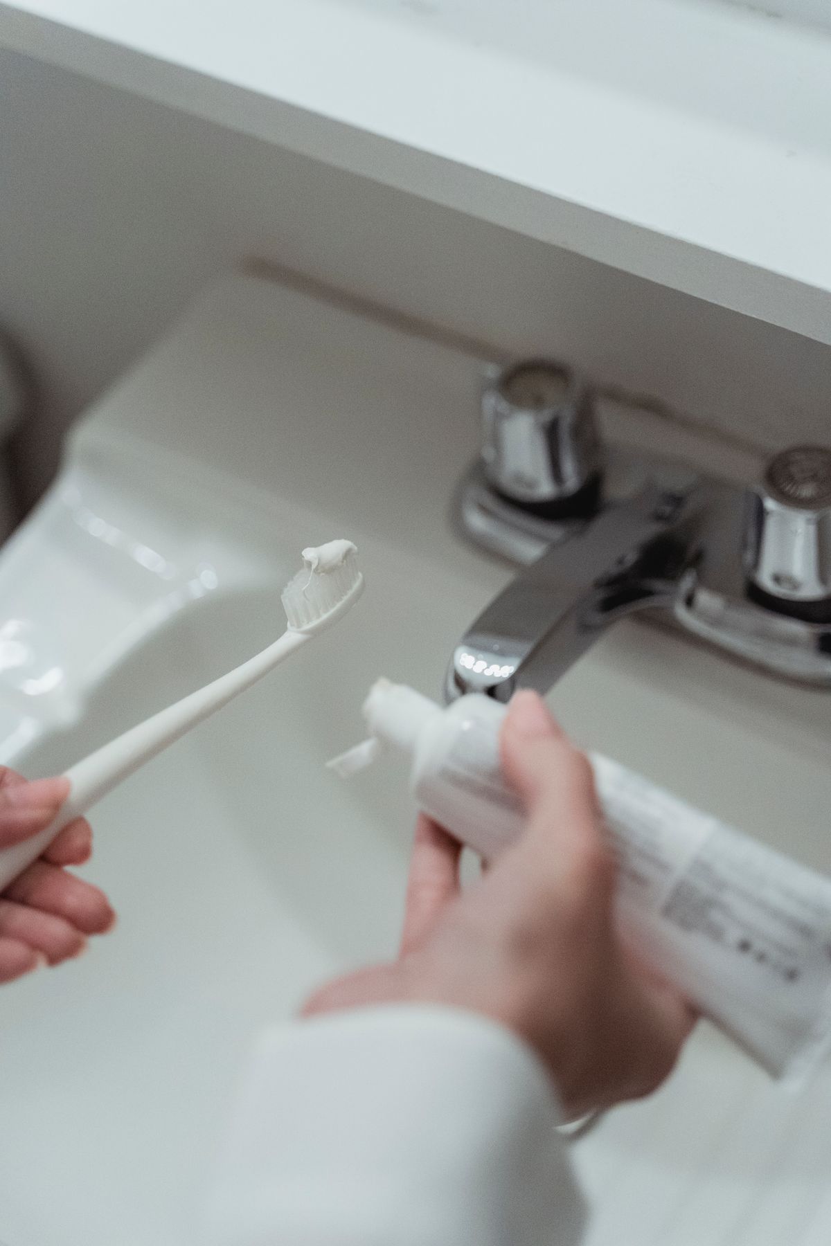 Person preparing a toothbrush as part of a daily oral-care routine